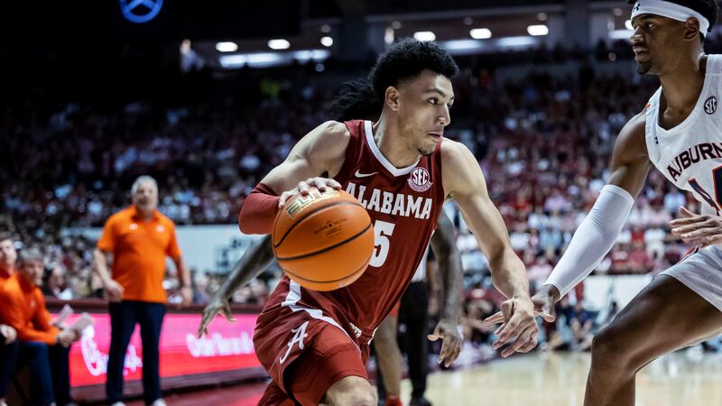 Alabama guard Jahvon Quinerly (5) drives against Auburn center Dylan Cardwell (44) during the...