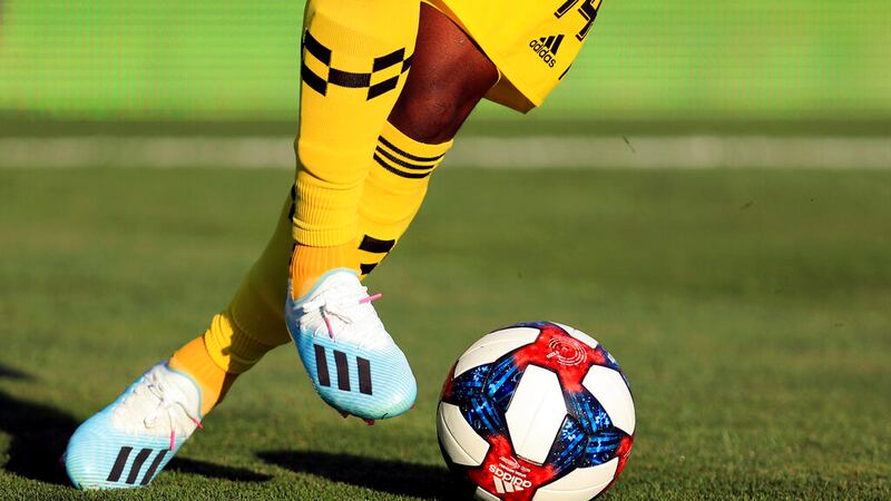 A view of the Adidas cleats worn by Columbus Crew Waylon Francis as he dribbles the game ball...