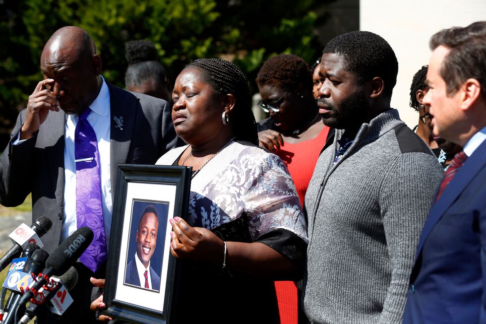 Caroline Ouko, mother of Irvo Otieno, holds a portrait of her son with attorney Ben Crump,...