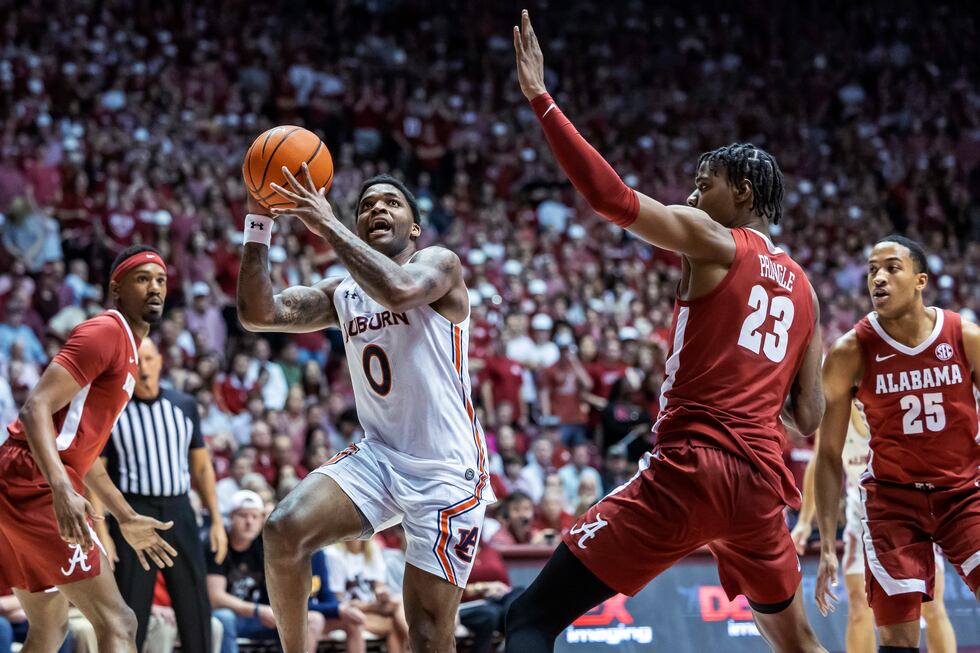 Auburn guard K.D. Johnson (0) drives past Alabama forward Nick Pringle (23) during the first...